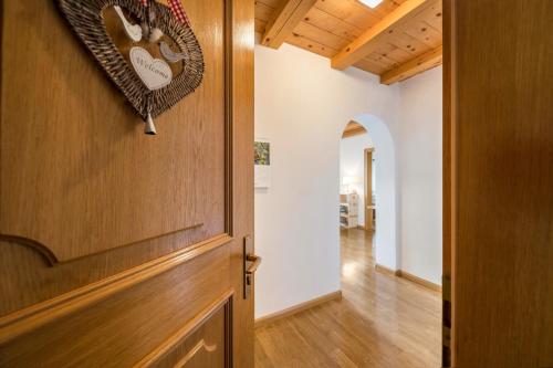 a hallway with a wooden door and a hallway with a room at Eichernhof Apartment Marillenblüte in Verano
