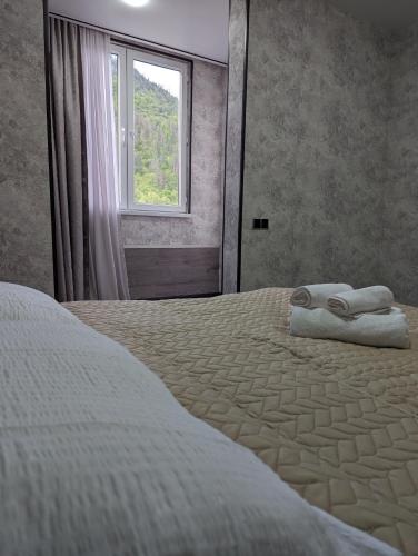 a bedroom with a bed with two towels on it at Gari's apartment next to Borjomi Central Park in Borjomi