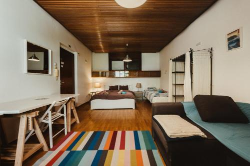a living room with a bed and a desk in a room at Pi House in Ljubljana