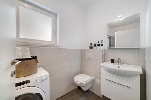 a white bathroom with a toilet and a sink at Haus Tanja Apartment 1 in Parcines
