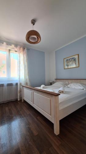 ein großes weißes Bett in einem Zimmer mit Fenster in der Unterkunft Appartements Clementina in Premantura