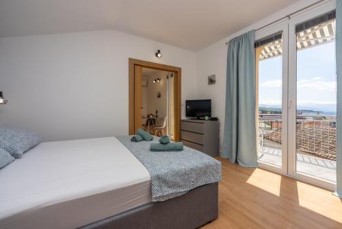 - une chambre avec un grand lit et un balcon dans l'établissement Apartments Kala, à Crikvenica
