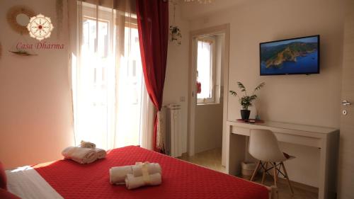 1 dormitorio con 1 cama roja y 2 toallas en Casa Dharma en Civitavecchia