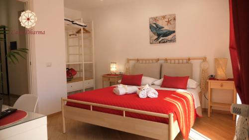 Un dormitorio con una cama roja con dos muñecas. en Casa Dharma, en Civitavecchia