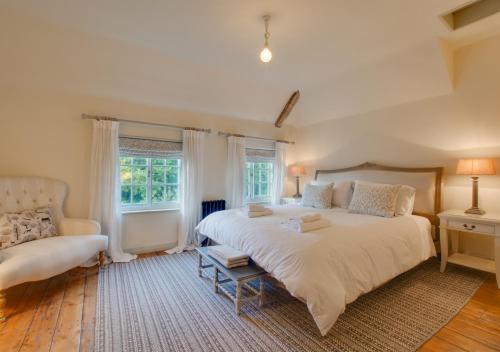 a bedroom with a large white bed and a couch at Baytree Cottage in Melton Constable