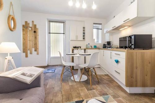 uma cozinha e uma sala de estar com mesa e cadeiras em Le Petit Clos, 3 étoiles em Pont-Saint-Martin