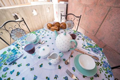 un tavolo con una tovaglia, una teiera e prodotti da forno di Sunset home Baia Blu a Gallipoli