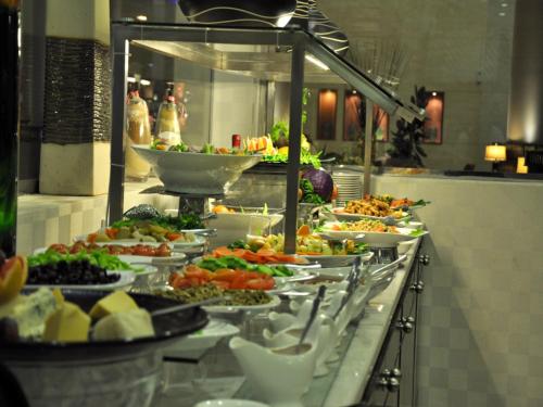 a buffet line with many different plates of food at Golden Tulip Hail in Hail