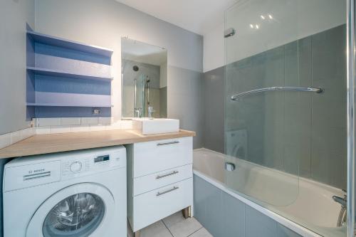 une salle de bain avec un lave-linge et une baignoire dans l'établissement Charmant appartement proche gare, à Nice