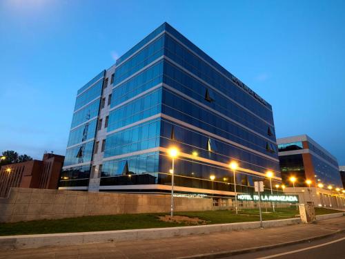 a tall glass building on the side of a street at NH La Avanzada in Leioa