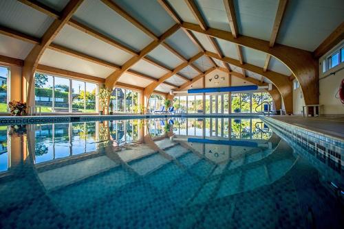 a large swimming pool with a large ceiling at Berthlwyd Coach House in Conwy