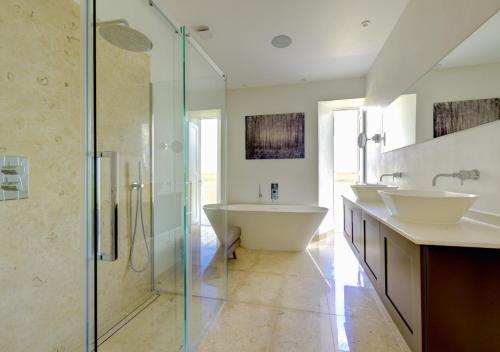 a bathroom with two sinks and a glass shower at Blue Tile Farm Barn in Saxlingham