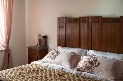 a bedroom with a bed with a wooden headboard at Lajatico Rentals - Casa di Alice nel Borgo in Laiatico
