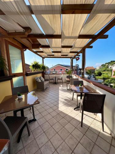 a patio with tables and chairs and awnings at B&B A Casa di Vittoria - Guest House in Castellabate