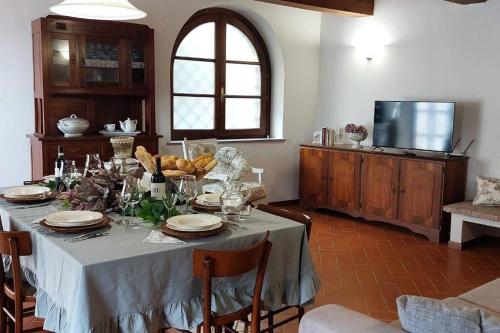 a dining room with a table with food on it at Lajatico Rentals - Casa di Alice nel Borgo in Laiatico