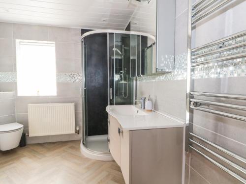 a bathroom with a shower and a sink and a toilet at Hawksbridge Bungalow in Macclesfield