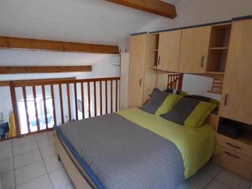 - une chambre avec un lit doté d'oreillers jaunes et bleus dans l'établissement Pavillon T2 Mezzanine, piscine, Mer Indigo, St Pierre la Mer, à Saint Pierre La Mer