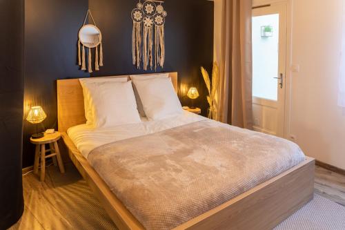 a bedroom with a large bed and two tables at Le Nordik Proche Roissy CDG - Paris - Astérix in Dammartin-en-Goële