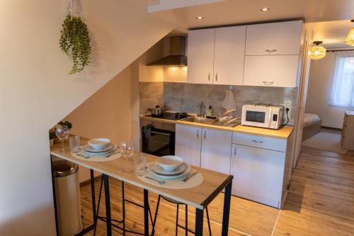 une petite cuisine avec une table et un micro-ondes dans l'établissement Le Nordik proche aéroport CDG I Paris I Astérix, à Dammartin-en-Goële