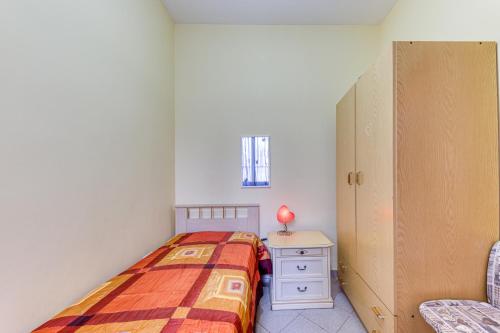 a small bedroom with a bed and a cabinet at Baia del Mare in Lido Marini