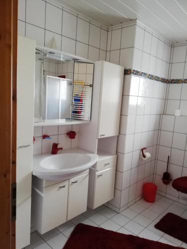 a white bathroom with a sink and a mirror at Sonniges Fleckchen in Griesheim