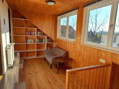 een kamer met een stoel en een boekenplank bij Klakbaan 14 in IJzendijke