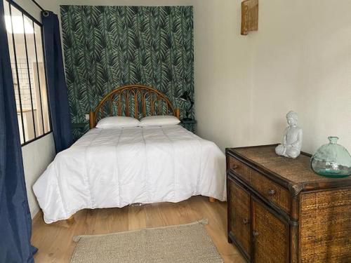 une chambre avec un lit et une commode en bois dans l'établissement Charmant T2 très cosy au calme en hyper centre., à Rochefort