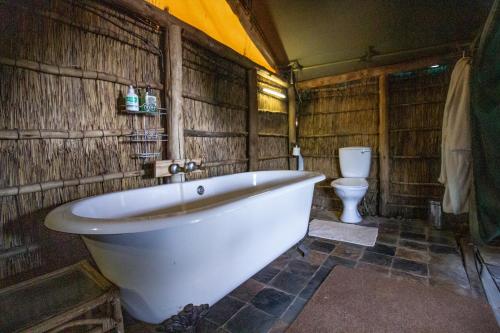 El baño incluye bañera blanca y aseo. en Inyala Game Lodge, en Ventersdorp