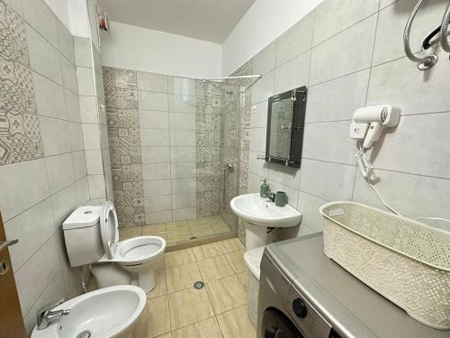 a bathroom with two toilets and a sink and a shower at Despacito Port Side in Vlorë