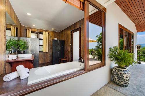 a bathroom with a tub and a large window at Villa Wassana - Sunset View 5Bed in Koh Samui 