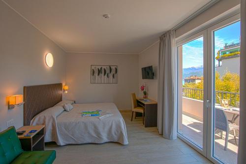 ein Hotelzimmer mit einem Bett und einem Balkon in der Unterkunft Hotel Boston in Stresa