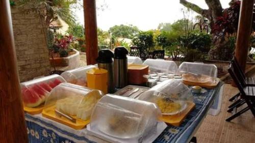 una tavola con molti contenitori di plastica per il cibo di Beleza Natural Pousada a Morro de São Paulo