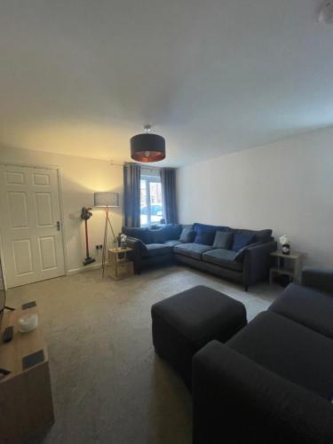 a living room with blue couches and a window at Baker House - Furnished Lets in Swinton