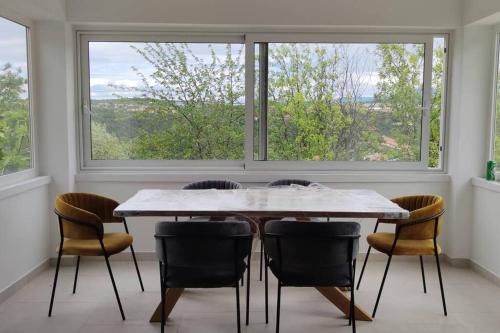 a dining room with a table and chairs and a window at Apartment Betty in Labin