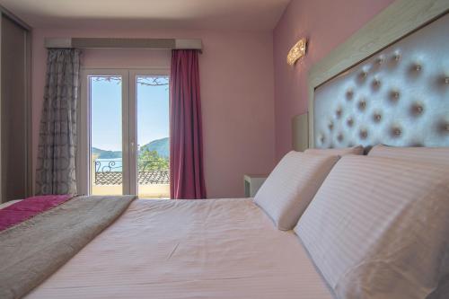 a bedroom with a large bed with a window at Villa Theodora View Apartments Klio in Corfu