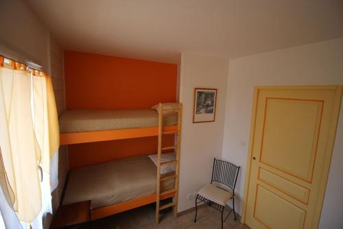 - une chambre avec 2 lits superposés et une chaise dans l'établissement Gîte Les Hauts Sauviers avec piscine et sauna, à Bédoin