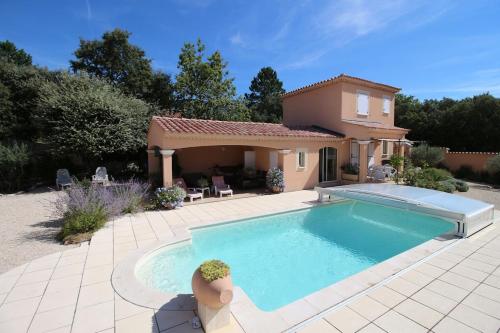 une maison avec une piscine dans une cour dans l'établissement Gîte Les Hauts Sauviers avec piscine et sauna, à Bédoin