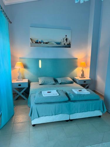 1 dormitorio azul con 1 cama y 2 mesitas de noche en Къща за Гости в Созополи, en Sozopoli