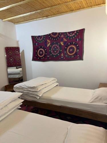 a room with two beds and a pillow on the wall at Hotel Legende in Samarkand