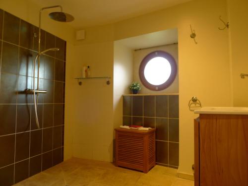 ein Bad mit einer Dusche und einem runden Fenster in der Unterkunft gîte de la Cabotte in Bussy-le-Grand
