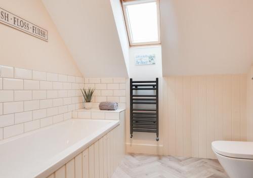 a bathroom with a bath tub and a toilet at Curlew Cottage in Wells next the Sea