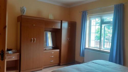 a bedroom with a bed and a dresser and a window at Spacious 6-Bed House 10 minutes from Knock Airport in Ballaghaderreen