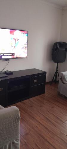a living room with a flat screen tv on a wall at Dawn Park Guest House in Boksburg