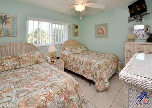 a bedroom with two beds and a ceiling fan at Tropic Breeze 17 in St. Pete Beach