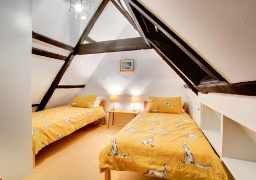 a bedroom with two beds in a attic at Cockleshells in Castle Acre