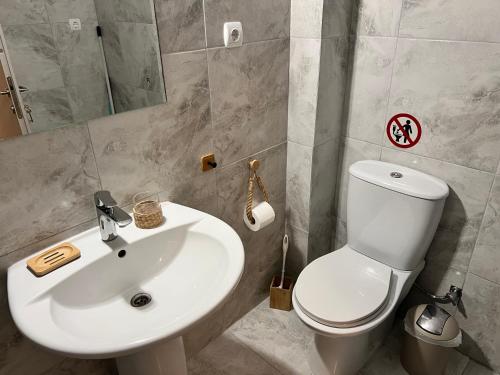 y baño con aseo blanco y lavamanos. en Къща за Гости в Созополи, en Sozopoli