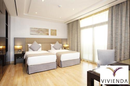 a hotel room with two beds and a desk at Vivienda Hotel Villas Granada in Riyadh