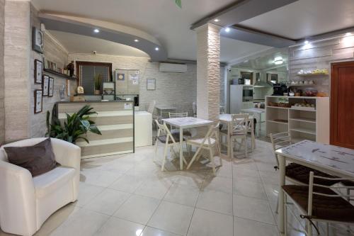 uma sala de estar com mesas e cadeiras e uma cozinha em Apart & Rooms Fotinov em Burgas