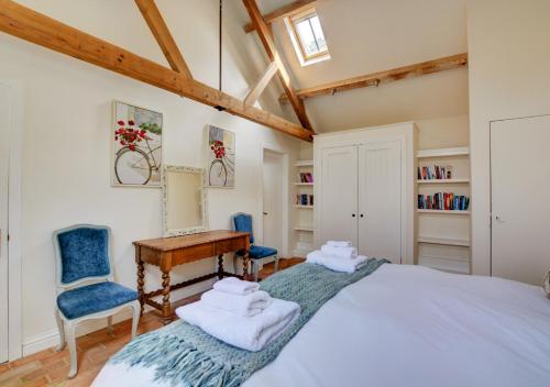a bedroom with a bed and a desk and chairs at Davids Barn in Langham