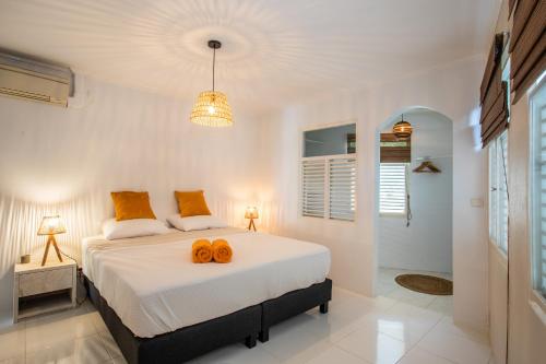 sypialnia z łóżkiem z pomarańczowymi poduszkami w obiekcie Villa Mai Blu w mieście Willemstad